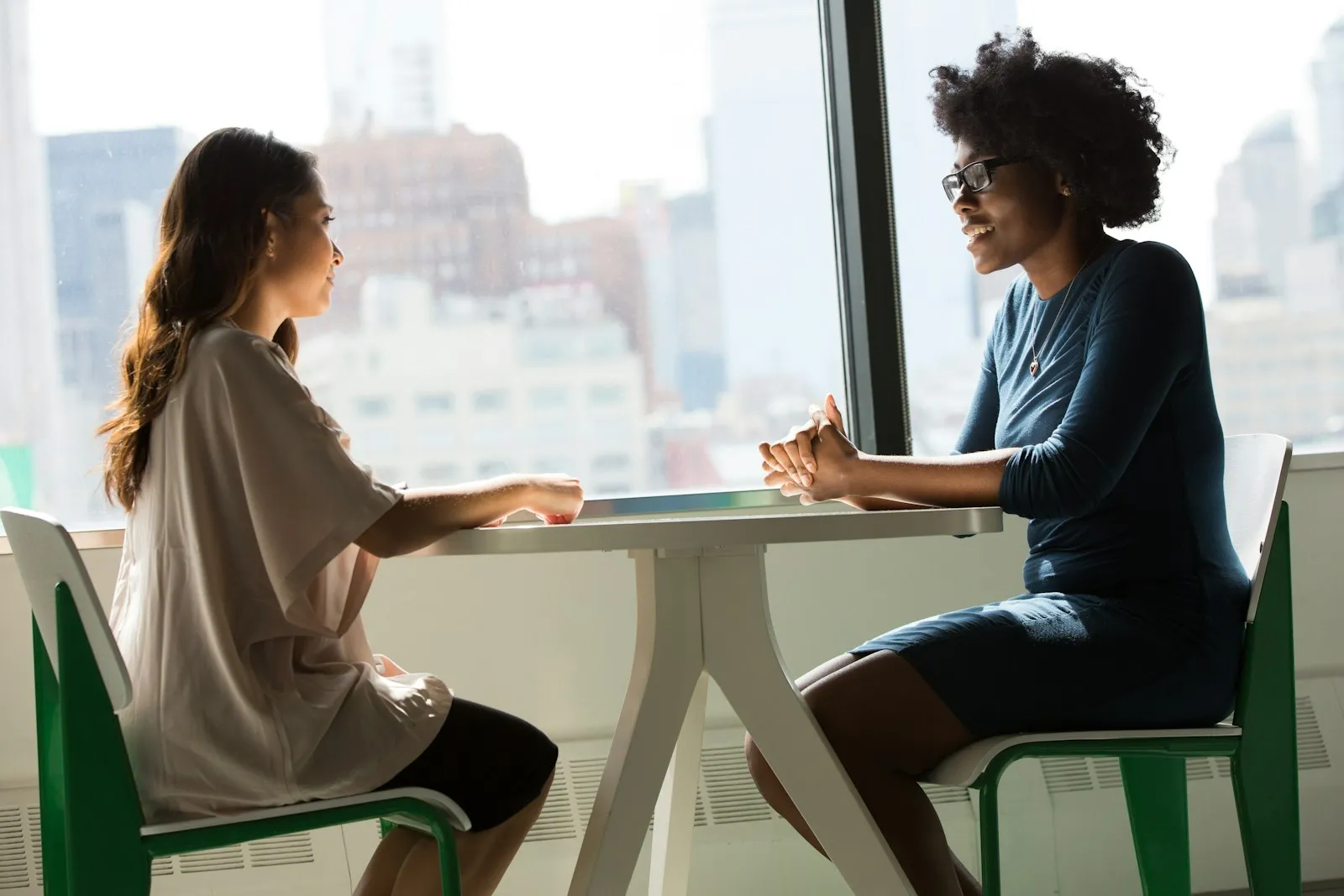 Duas pessoas conversando de forma próxima em uma reunião
